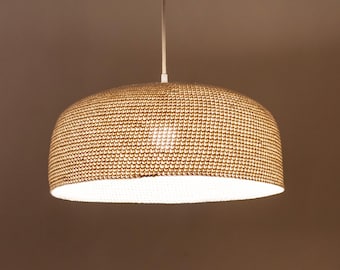 May include: A woven pendant light fixture with a round, dome-shaped shade. The shade is made of a light brown material and has a white interior.