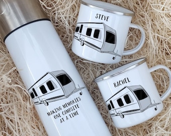 May include: A white insulated travel mug with a black and white illustration of a camper and the text "Making memories one campsite at a time". Two white enamel mugs with black and white camper illustrations and the names "Steve" and "Rachel" are also included.