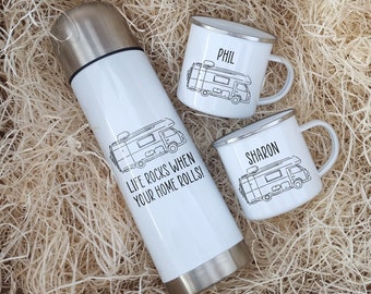 May include: A white insulated travel mug with the text "Life rocks when your home rolls!" and a black and white illustration of a camper van. Two white enamel mugs with black and white camper van illustrations and the names "Phil" and "Sharon" are also pictured.