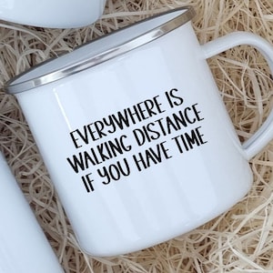 K&ouml;nnte beinhalten: Wei&szlig;e Emaille-Camping-Tasse mit schwarzer Aufschrift "Everywhere is walking distance if you have time."