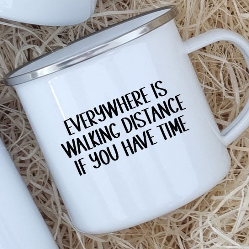 K&ouml;nnte beinhalten: Wei&szlig;e Emaille-Camping-Tasse mit schwarzer Aufschrift "Everywhere is walking distance if you have time."
