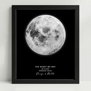 May include: Framed print with a black border, showcasing a detailed grayscale image of the moon against a black backdrop. Text includes "THE NIGHT WE MET", a date, location, and names.