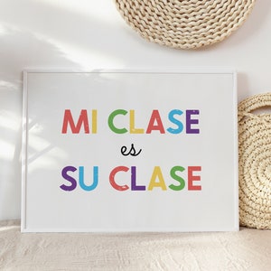 May include: A white framed print with the text "MI CLASE es SU CLASE" in colorful letters. The letters are in different colors, including red, orange, yellow, green, blue, and purple.