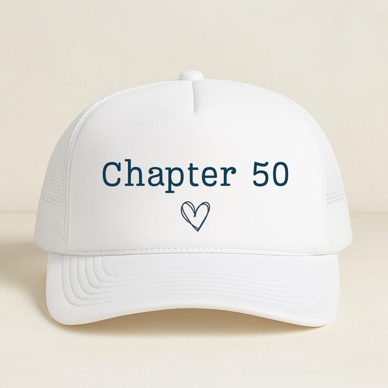 May include: White trucker hat with the text "Chapter 50" in navy blue, along with a small heart symbol. The hat features a mesh back and a curved brim. A casual accessory.