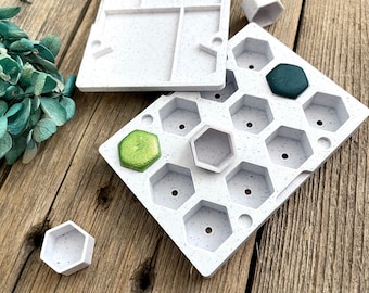 May include: White plastic tray with 12 hexagonal compartments. The tray is filled with small green and dark green paint pots.