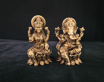 Peut inclure: Statues dorées à l'or fin des divinités hindoues Lakshmi et Ganesha. Les deux figures sont assises sur des bases de fleurs de lotus et sont ornées de détails complexes.