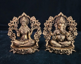 Peut inclure: Statues en métal doré de Lakshmi et Ganesha, divinités hindoues, assises sur des socles ornés de motifs floraux.