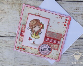 May include: A handmade greeting card with a cartoon girl illustration holding flowers. The card has a pink scalloped edge, decorative paper, and red ribbon accents. The text on the card reads "Sending Special Wishes Already Surpassed."
