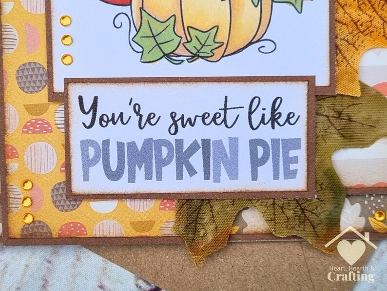 Peut inclure: Une carte de v&oelig;ux artisanale avec un panneau rectangulaire portant le texte noir et gris You're sweet like PUMPKIN PIE. La carte est d&eacute;cor&eacute;e avec du papier &agrave; motifs jaunes, de petites gemmes dor&eacute;es et une d&eacute;coupe de feuille d'automne en tissu.