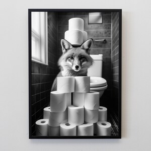 Puede incluir: Impresi&oacute;n enmarcada en blanco y negro de un zorro en un ba&ntilde;o. El zorro est&aacute; rodeado de rollos de papel higi&eacute;nico, algunos apilados sobre su cabeza. El fondo incluye un inodoro, una ventana y paredes alicatadas.