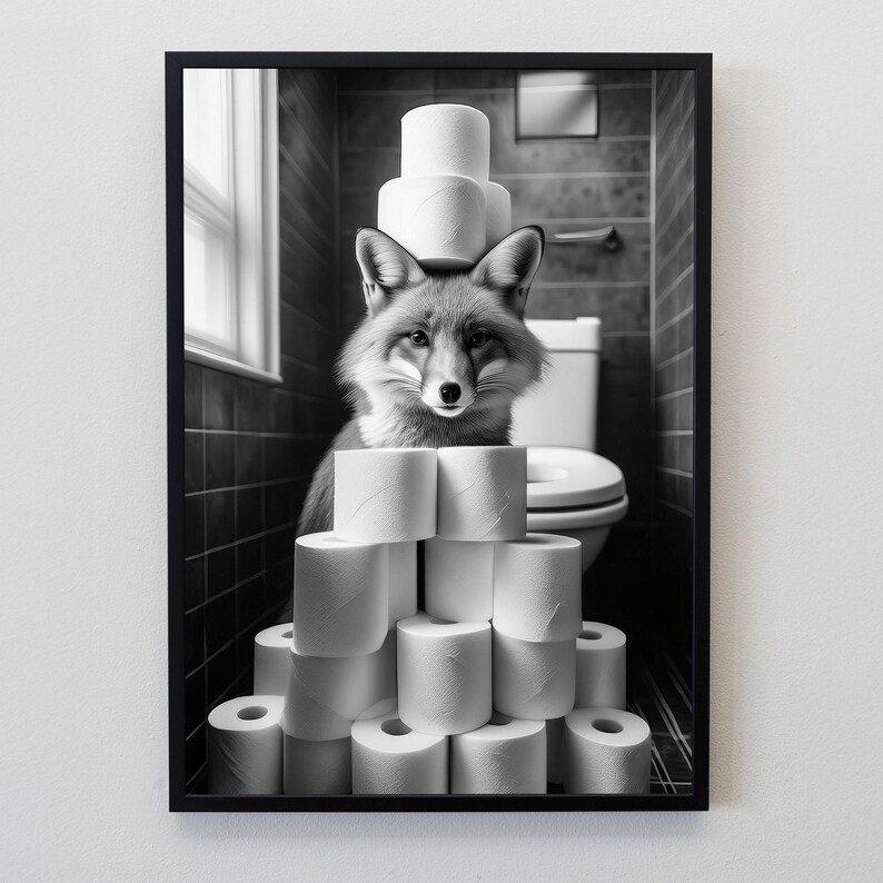 Puede incluir: Impresi&oacute;n enmarcada en blanco y negro de un zorro en un ba&ntilde;o. El zorro est&aacute; rodeado de rollos de papel higi&eacute;nico, algunos apilados sobre su cabeza. El fondo incluye un inodoro, una ventana y paredes alicatadas.