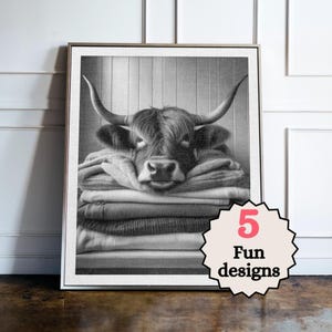 May include: Monochrome framed print of a Highland cow resting on a pile of folded blankets. The image includes the text "5 Fun designs" in a decorative badge.