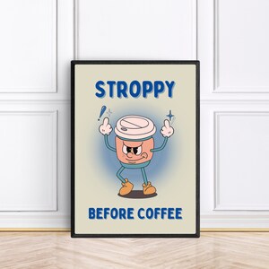 Może przedstawiać: Beżowy plakat w czarnej ramie przedstawiający kresk&oacute;wkową filiżankę kawy z kwaśną miną i tekstem "STROPPY BEFORE COFFEE".