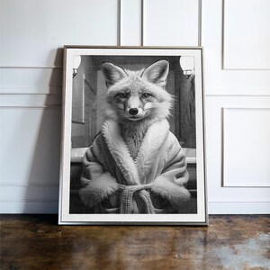 Puede incluir: Impresi&oacute;n enmarcada en blanco y negro que presenta un zorro con una bata. El zorro est&aacute; sentado, con una expresi&oacute;n seria, en un entorno de ba&ntilde;o. La obra de arte tiene un estilo vintage y caprichoso, adecuado para la decoraci&oacute;n del hogar.