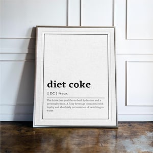 Może przedstawiać: Oprawiony wydruk artystyczny z definicją diet coke w stylu słownikowym. Tekst brzmi: diet coke [ DC ] Noun. The drink that qualifies as both hydration and a personality trait. A fizzy beverage consumed with loyalty and absolutely no intention of switching to water.
