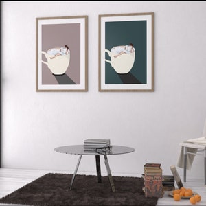 May include: Two framed prints of a woman reading a book while relaxing in a cup of coffee. The prints are in different color schemes, one with a pink background and the other with a teal background.