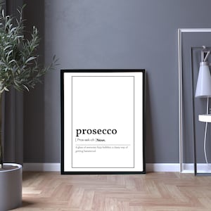 May include: A framed black and white print with the definition of "prosecco." The definition reads: "A glass of awesome fizzy bubbles, a classy way of getting hammered." The print is displayed on a wooden floor.