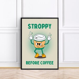 Może przedstawiać: Czarny plakat w ramie z kresk&oacute;wkową ilustracją kubka z kawą z kwaśną miną i tekstem "STROPPY BEFORE COFFEE".