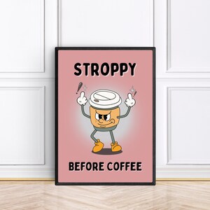 Może przedstawiać: R&oacute;żowo-czarny plakat w ramie z kresk&oacute;wkową filiżanką kawy z kwaśną miną. Tekst na plakacie brzmi "STROPPY BEFORE COFFEE".