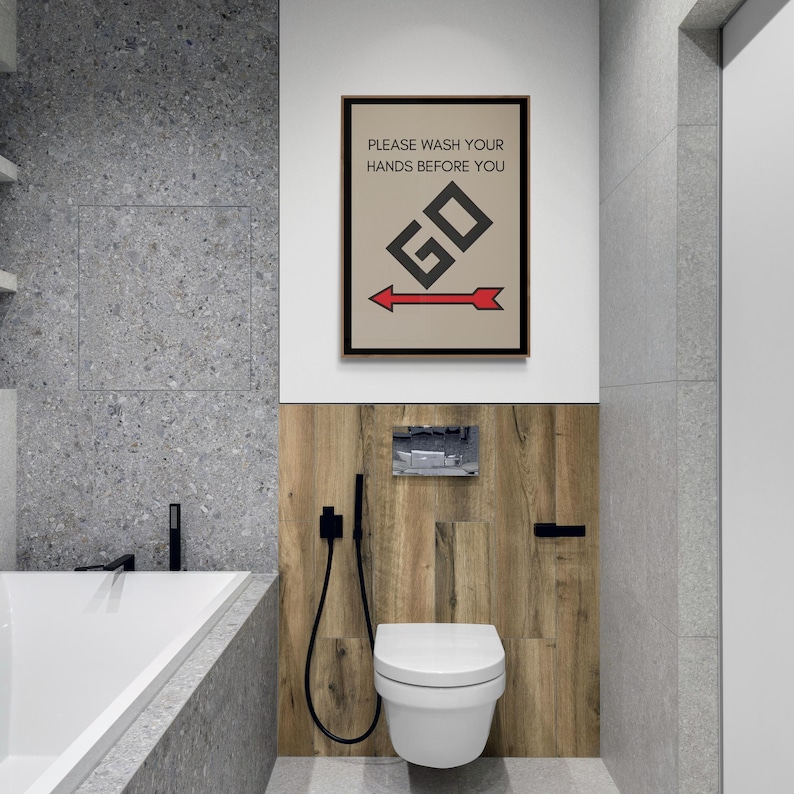 May include: A bathroom sign with a brown frame and a beige background. The sign reads "Please wash your hands before you" with a black and white graphic of the word "GO" and a red arrow pointing to the right.