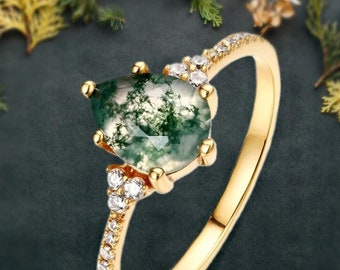 May include: A gold ring with a pear-shaped green agate gemstone surrounded by small clear stones.