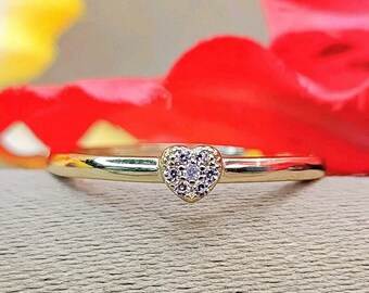 May include: A gold ring with a heart-shaped center set with small diamonds.