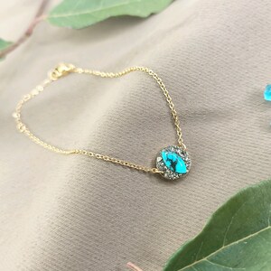 May include: A gold chain bracelet with a turquoise and pyrite stone pendant.