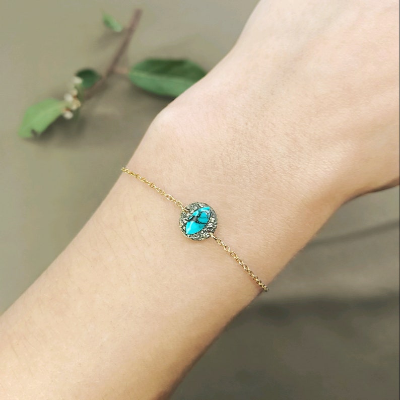 May include: A gold chain bracelet with a turquoise and gold oval charm.