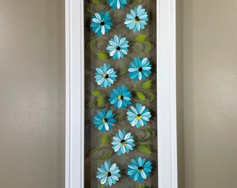 Teal flowers painted on glass.
