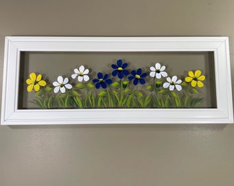 Blue, white, and yellow flowers painted on glass.
