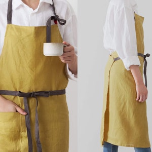 The front and side looking of charcoal linen apron which is dressed on.