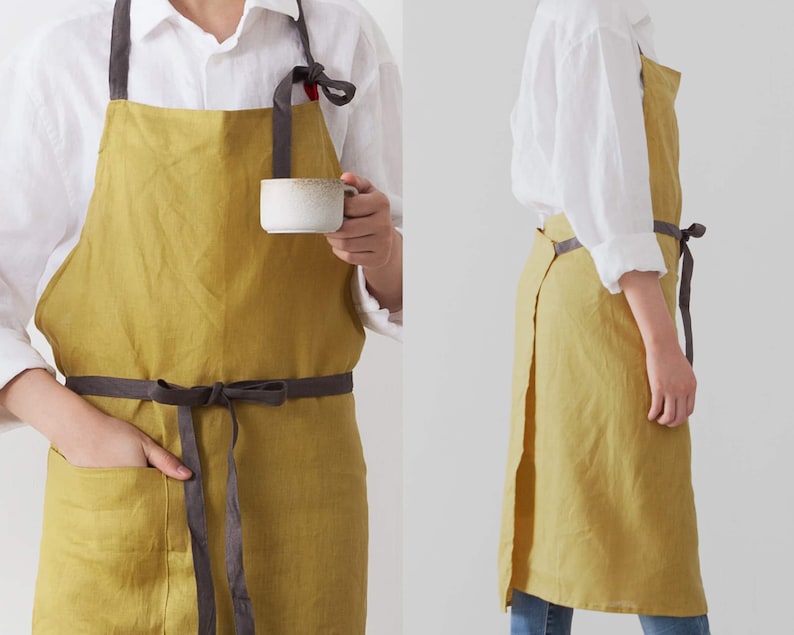 The front and side looking of charcoal linen apron which is dressed on.