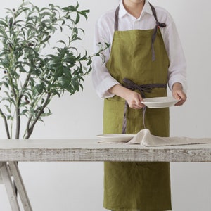 The front looking of green linen apron which is dressed on.