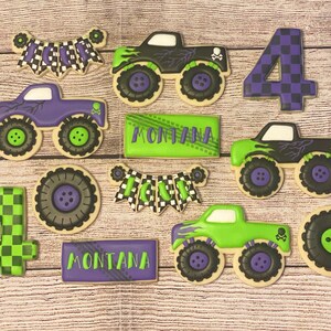 May include: A set of nine decorated sugar cookies featuring monster trucks, chequered flags, and the name "Montana". The cookies are decorated in shades of green, purple, and black.