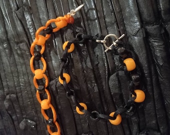 May include: A black and orange beaded necklace and bracelet set. The necklace has a silver clasp and the bracelet has a silver toggle clasp.