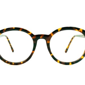 May include: Tortoiseshell round eyeglasses with clear lenses.