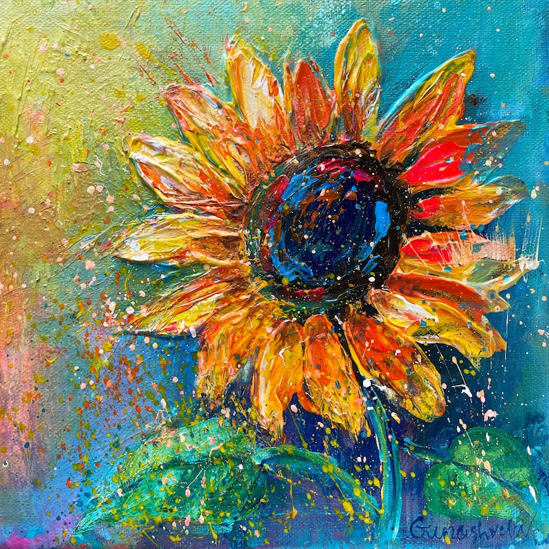 May include: A vibrant, textured painting of a sunflower with yellow, orange, and red petals. The center is dark blue, and the background is a mix of blue, green, and yellow with paint splatters. The artwork is signed.