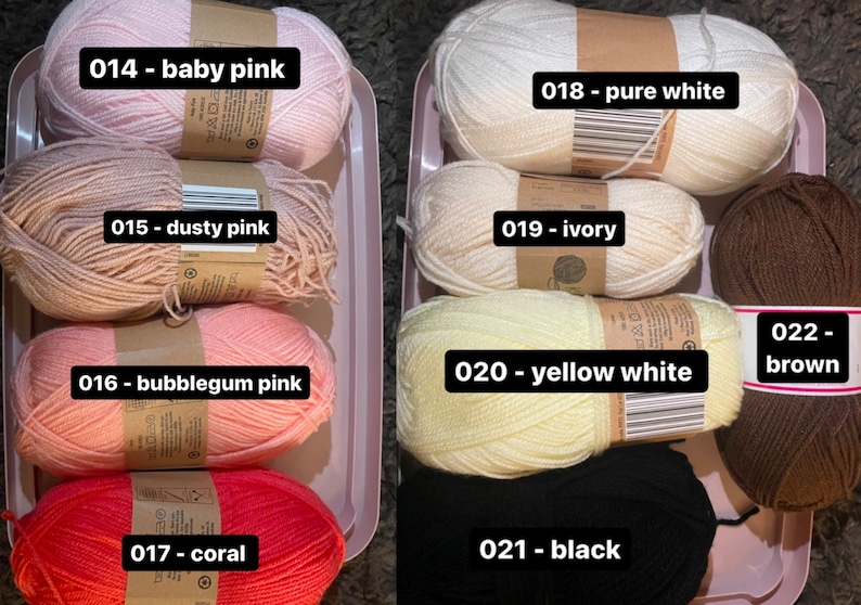 May include: Assortment of yarn skeins in various colors, including baby pink, dusty pink, bubblegum pink, coral, pure white, ivory, yellow white, brown, and black. Each skein is labeled with its color name.