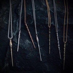 Puede incluir: Siete collares de plata, oro y bronce con colgantes de varita m&aacute;gica. Las varitas son de diferentes estilos y longitudes.
