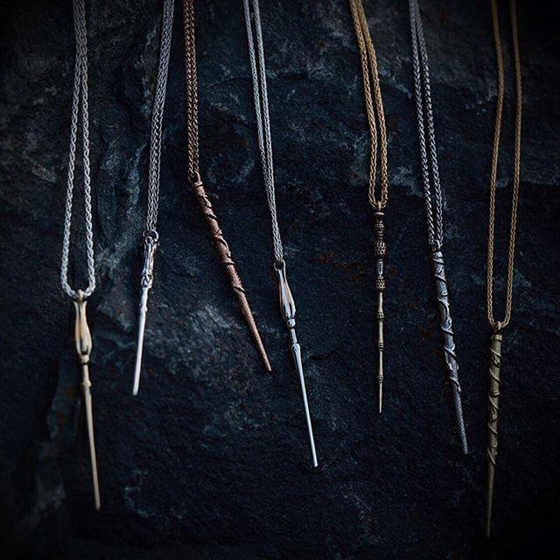 Puede incluir: Siete collares de plata, oro y bronce con colgantes de varita m&aacute;gica. Las varitas son de diferentes estilos y longitudes.