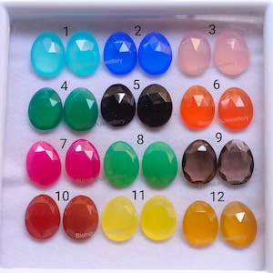 Peut inclure: Douze paires de cabochons de pierres précieuses facettées de différentes couleurs, numérotées de 1 à 12. Les pierres sont disposées en deux rangées de six, chaque paire de pierres partageant le même numéro.