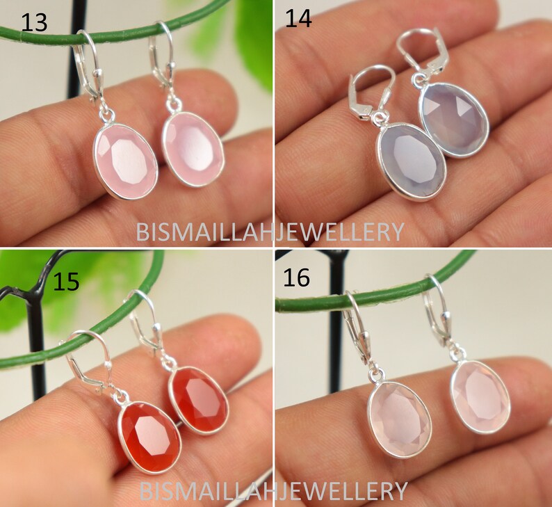 May include: Four pairs of silver dangle earrings with different colored gemstone drops. The earrings are displayed on a hand with a green background. The earrings are numbered 13, 14, 15, and 16.