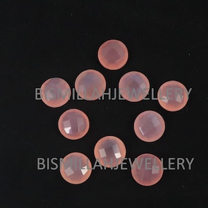 May include: Eight pink chalcedony cabochons, each with a faceted surface, arranged in a star shape on a black background.