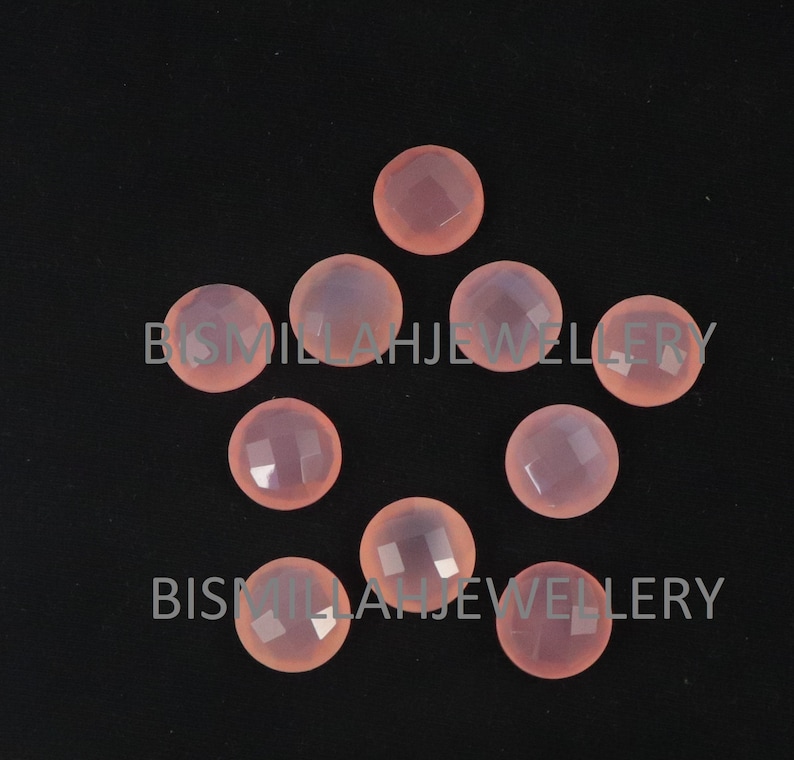 May include: Eight pink chalcedony cabochons, each with a faceted surface, arranged in a star shape on a black background.