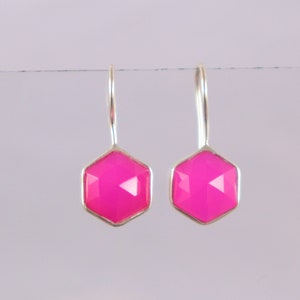 May include: A pair of silver dangle earrings with pink hexagonal gemstones.
