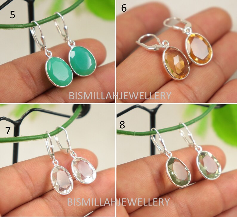 May include: Four pairs of silver dangle earrings with oval-shaped gemstones. The earrings feature a green, yellow, clear, and light green gemstone.
