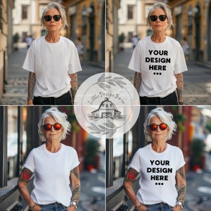 May include: White t-shirts with short sleeves. One shirt has the text "YOUR DESIGN HERE" in black. The model is wearing sunglasses and has tattoos on their arms. The background is a blurred outdoor scene.