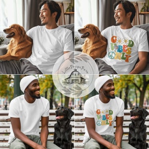 May include: White t-shirt with a colorful graphic that says "Good Vibes Only" with flowers and smiley faces. The shirt is being modeled by a person with a dog.