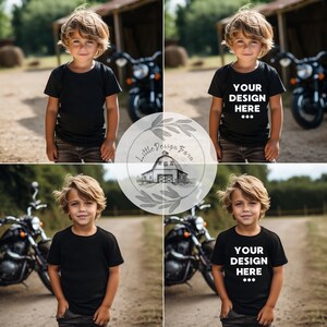 May include: A young boy wearing a black t-shirt with the text "YOUR DESIGN HERE***" printed on it. He is standing in front of a motorcycle and looking at the camera.