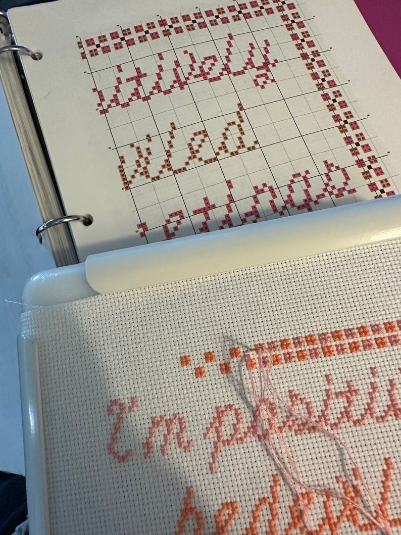 May include: A close-up of a cross-stitch project in progress. The project is a pink and orange cross-stitch design that reads "I'm pretty sure I'm a wizard".